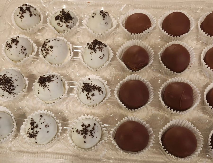 Cake balls dipped in white chocolate with cookie crumbs and in milk chocolate