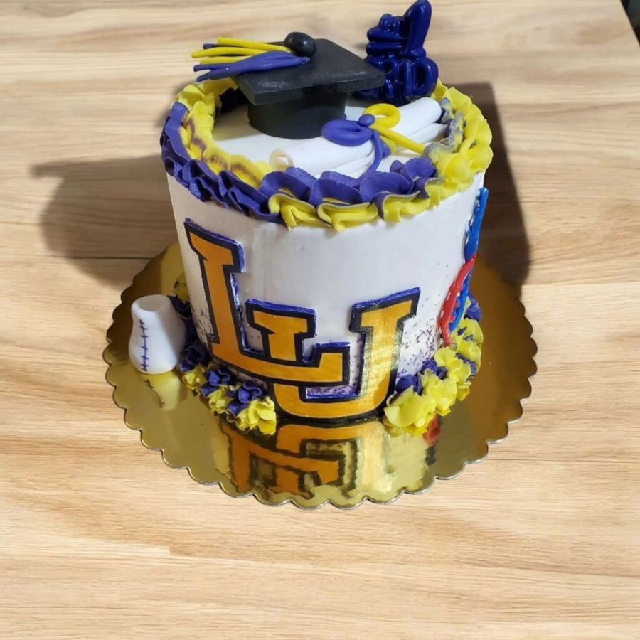 Purple and gold graduation cake with a cap, diploma and varsity letters